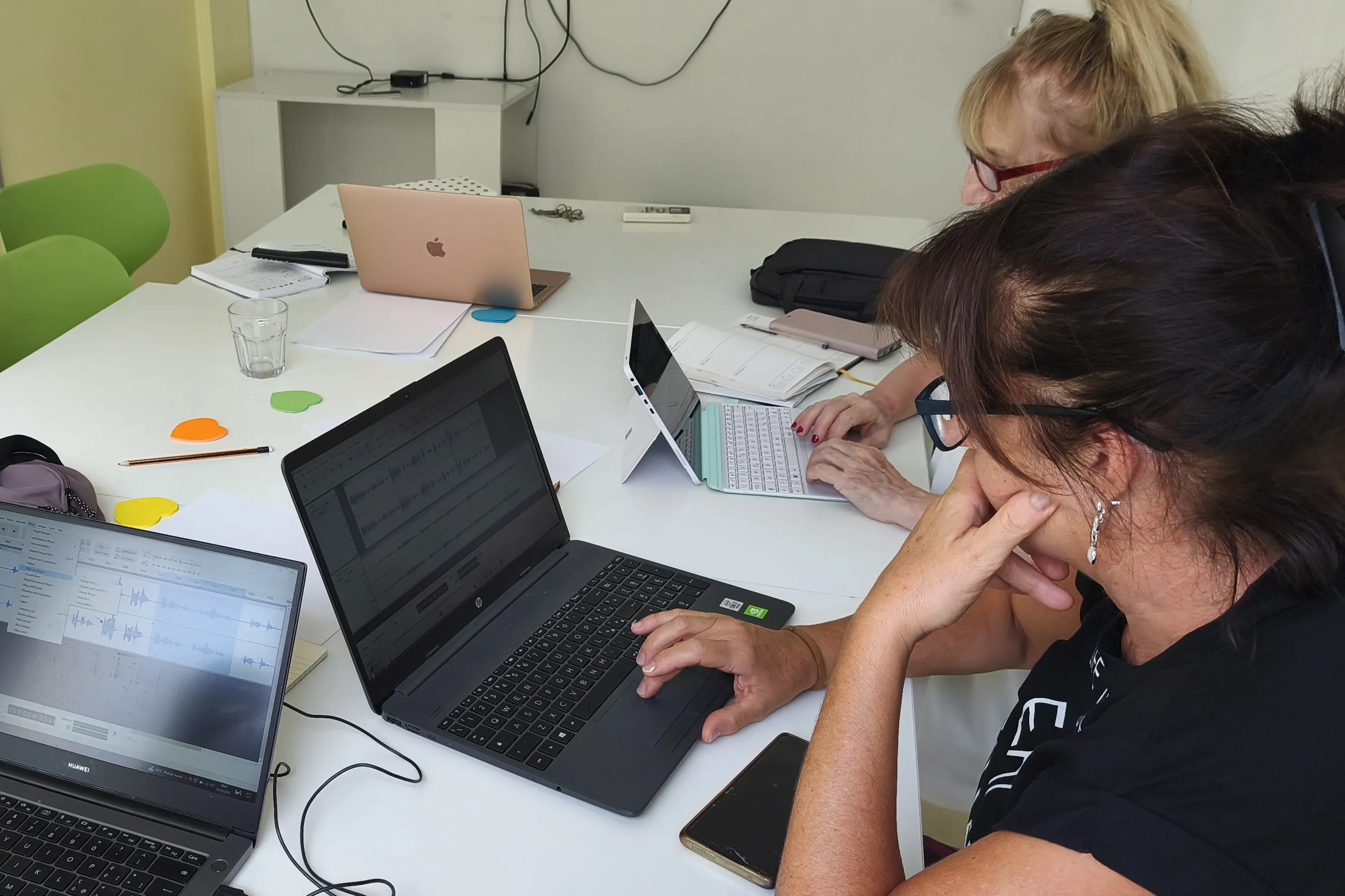 Three teachers working side by side on laptops around a table during a course at IIF