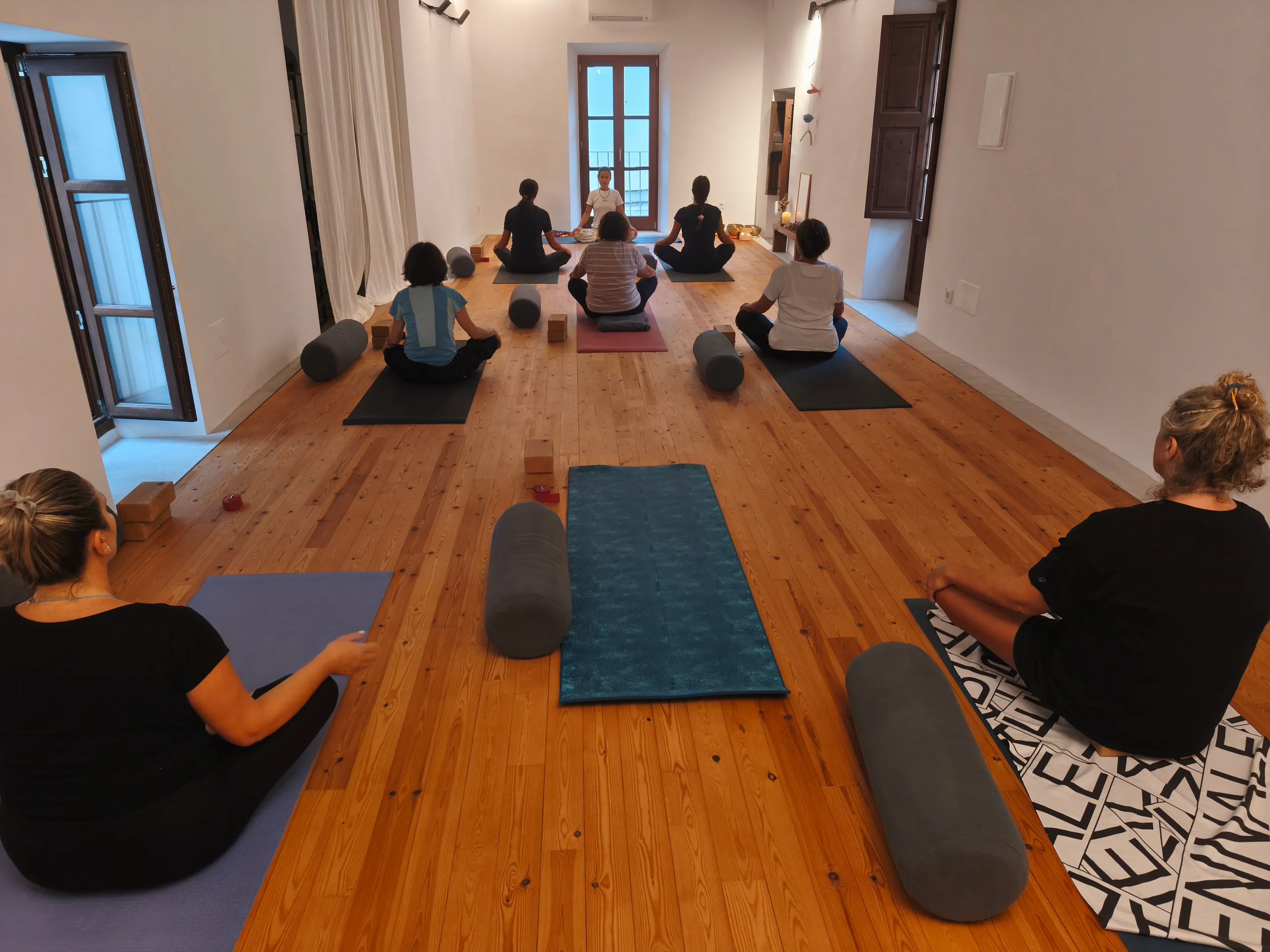 Teachers in a guided yoga session outdoors during the Wellbeing course in Artà